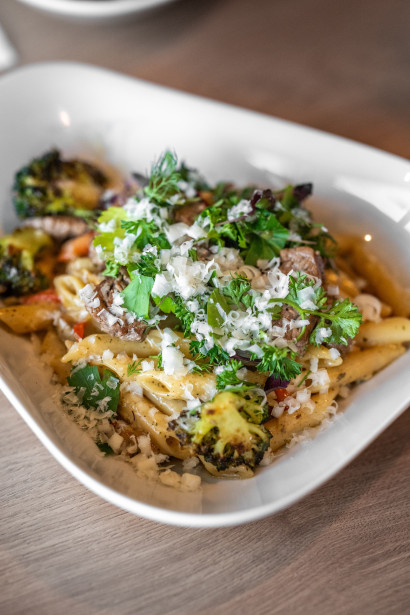 Plate with pasta, vegetables, and freshly grated Parmesan.