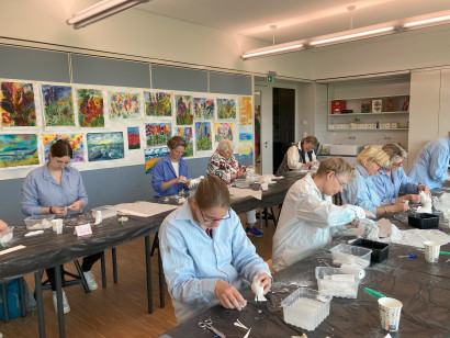 Malkursteilnehmende arbeiten konzentriert mit Gips in der Malschule Seebüll.